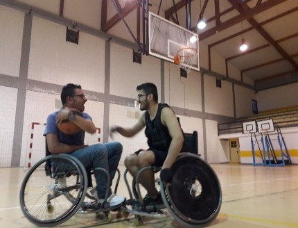 Dos hombres en silla de ruedas jugando al baloncesto